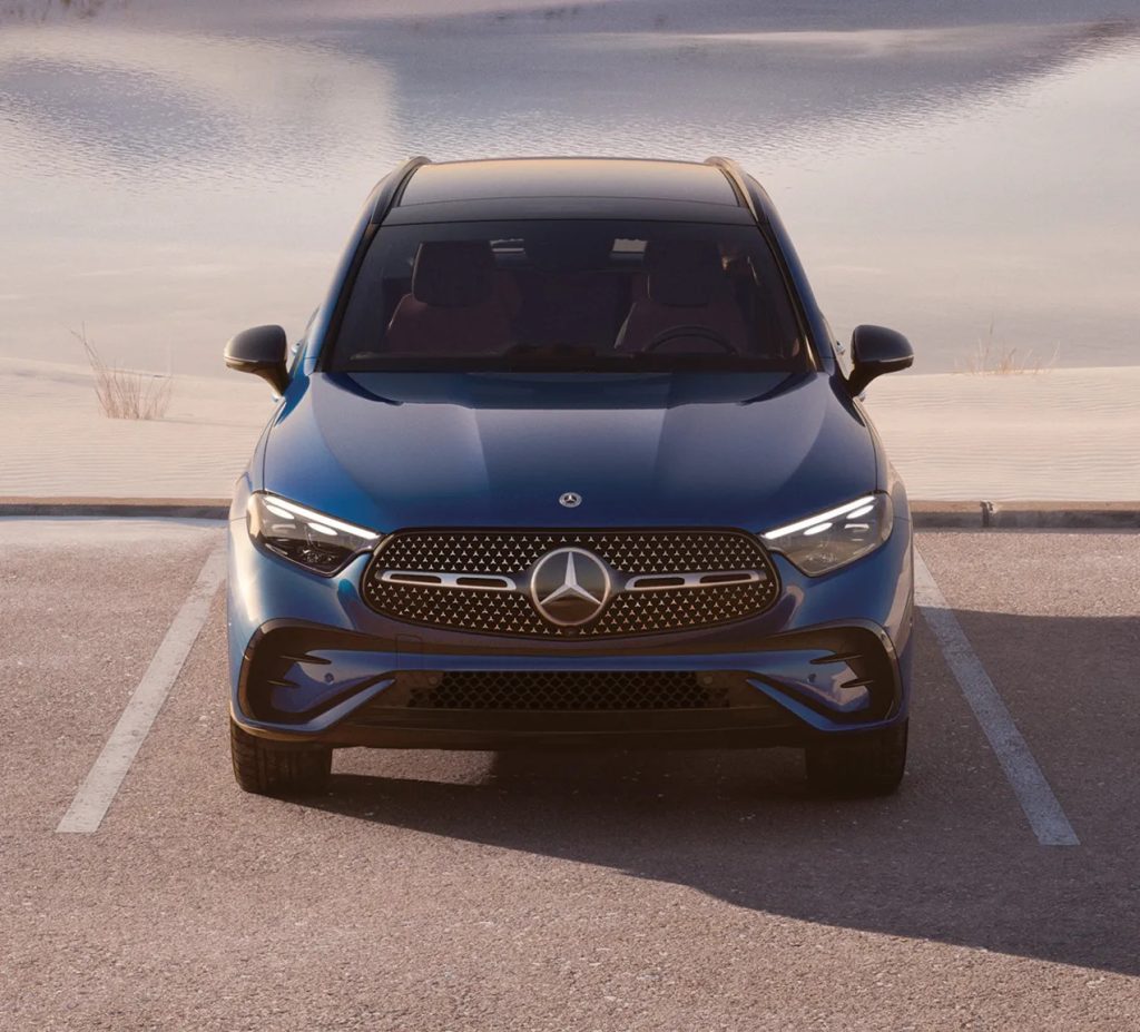 Front-facing view of the 2026 Mercedes-Benz GLC in deep blue, parked outdoors with its signature grille and LED lighting design.