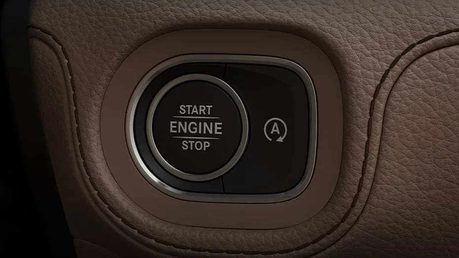 Close-up of the Mercedes-AMG® GLE 53 engine start/stop button with premium leather stitching detail.