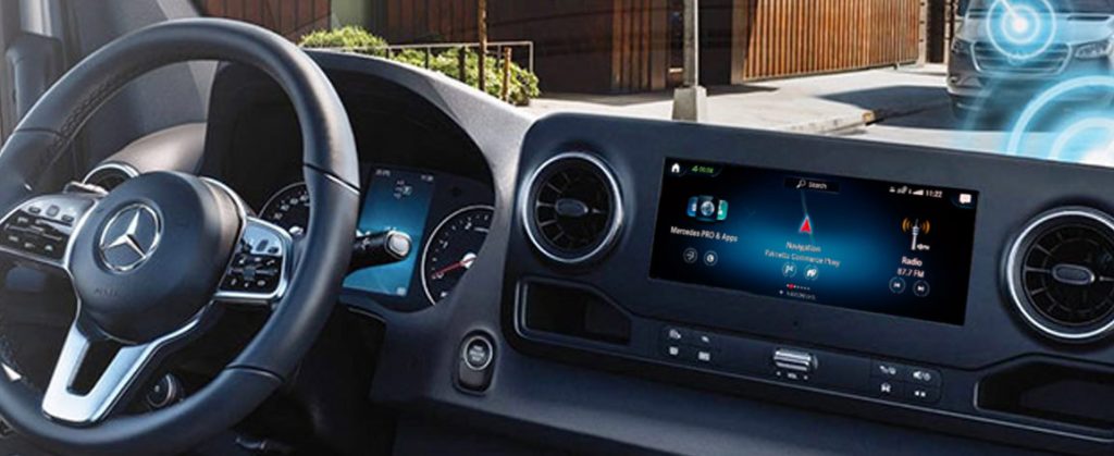 Close-up of a Mercedes-Benz Sprinter Van dashboard featuring the steering wheel, digital display, and infotainment screen.
