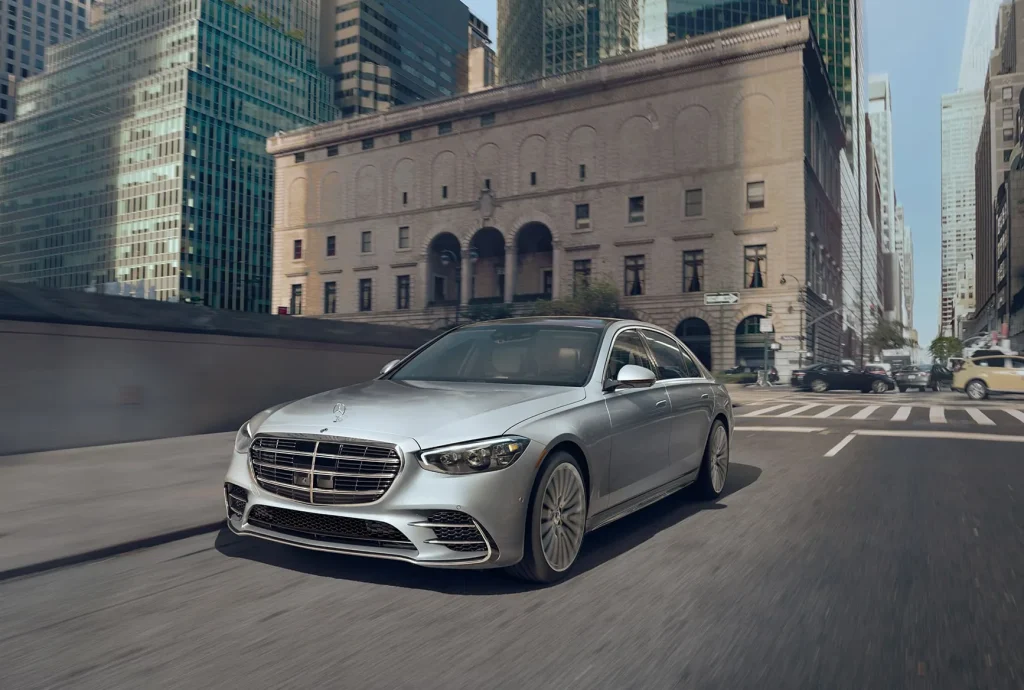 2027 Mercedes-Benz S-Class flagship sedan driving through a city street.