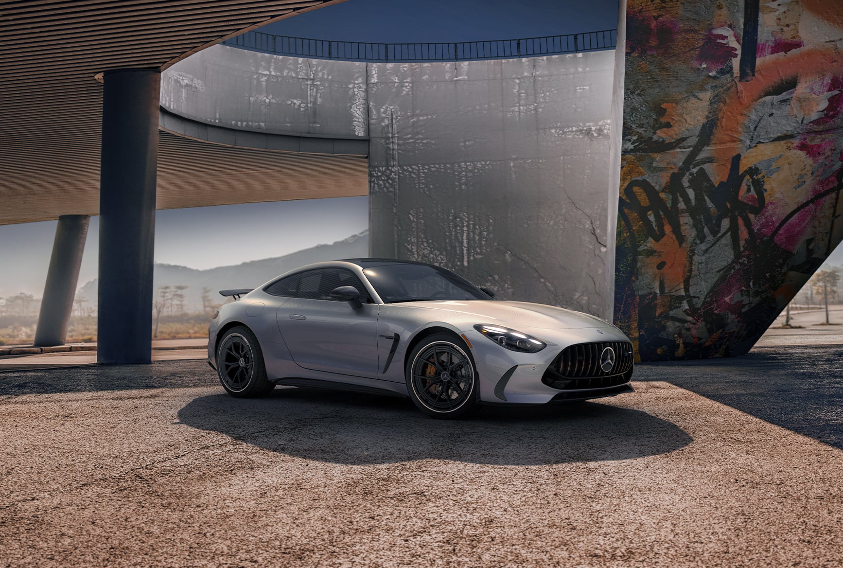 Silver 2027 Mercedes-Benz AMG GT 55 Coupe parked beneath a modern structure.