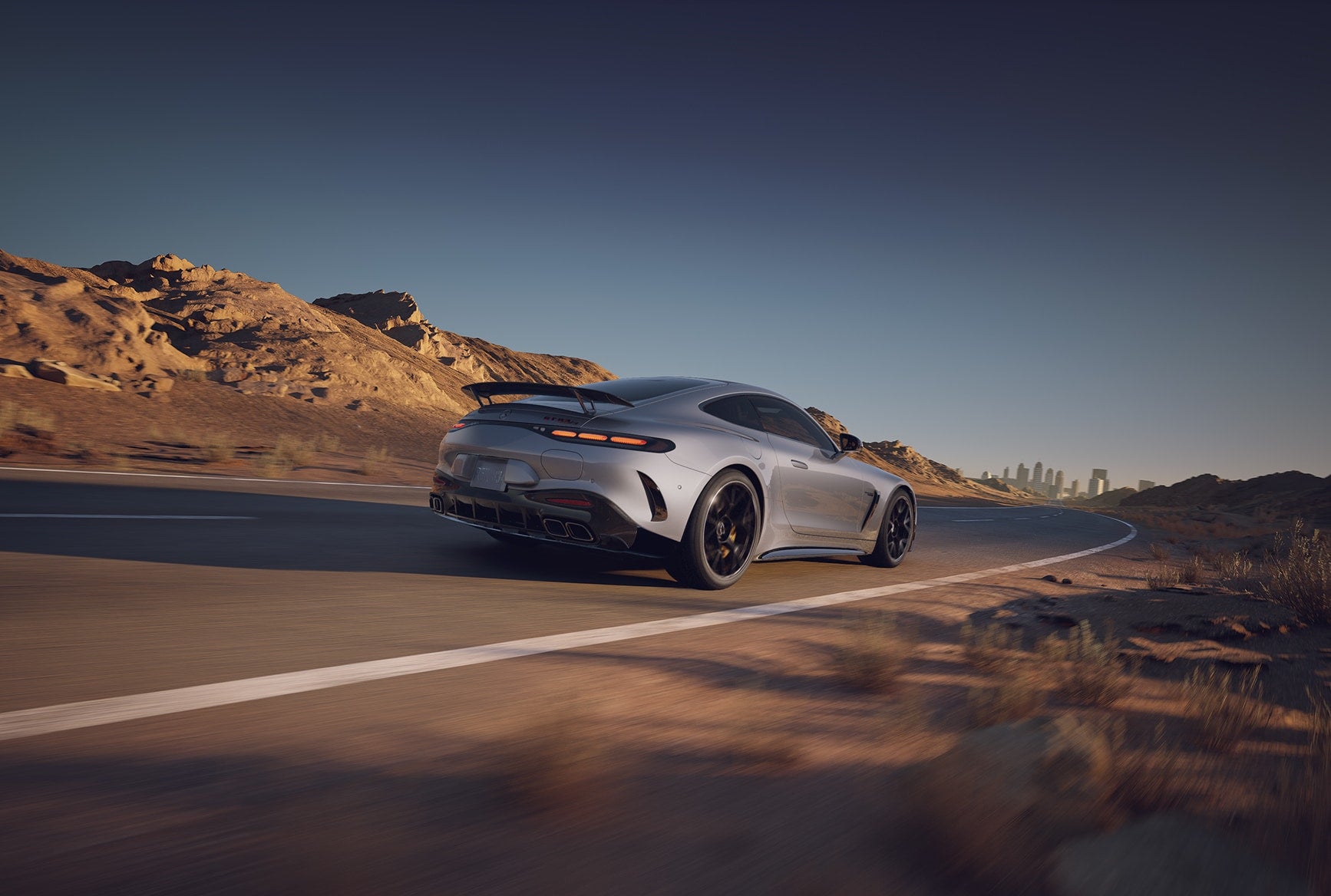 Rear view of the 2027 Mercedes-Benz AMG GT 63 S E PERFORMANCE Coupe driving on a winding highway.
