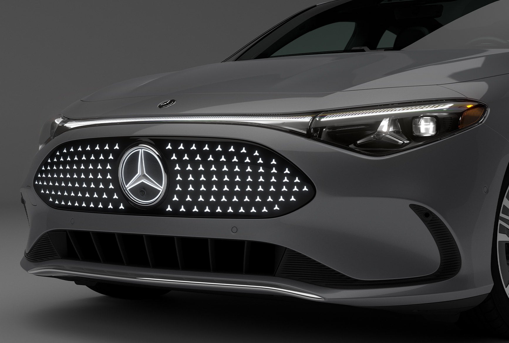 Close-up of the 2027 Mercedes-Benz CLA Sedan front end showing advanced lighting technology, illuminated grille, Mercedes-Benz emblem, and LED headlights.