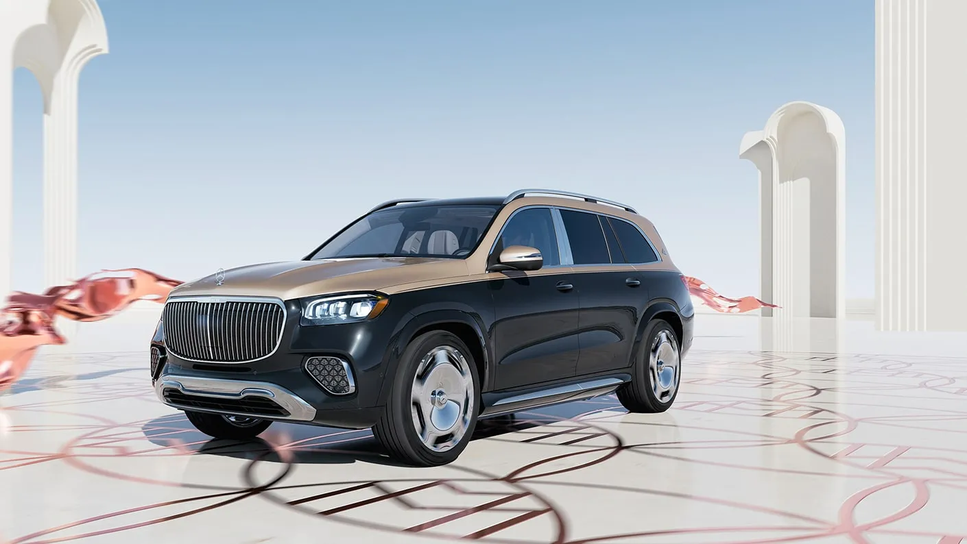 Mercedes-Maybach GLS luxury SUV shown at a front-side angle with two-tone paint, chrome wheels, and an elegant architectural setting