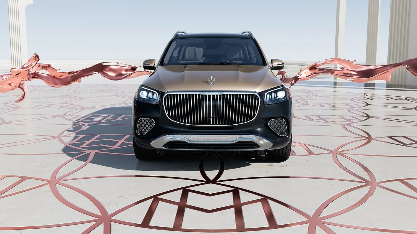 Mercedes-Maybach GLS luxury SUV shown from the front with a chrome grille, two-tone exterior, and elegant showroom-style backdrop.