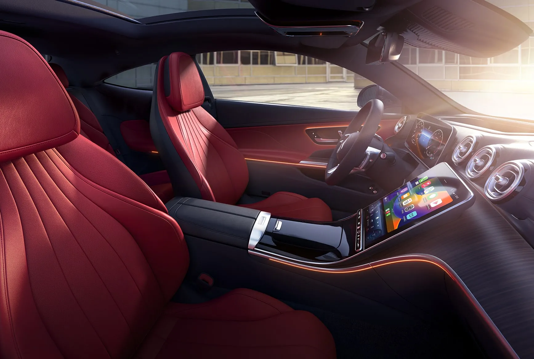 2027 Mercedes-Benz CLE Coupe interior with red leather seats, touchscreen display, and ambient cabin lighting.