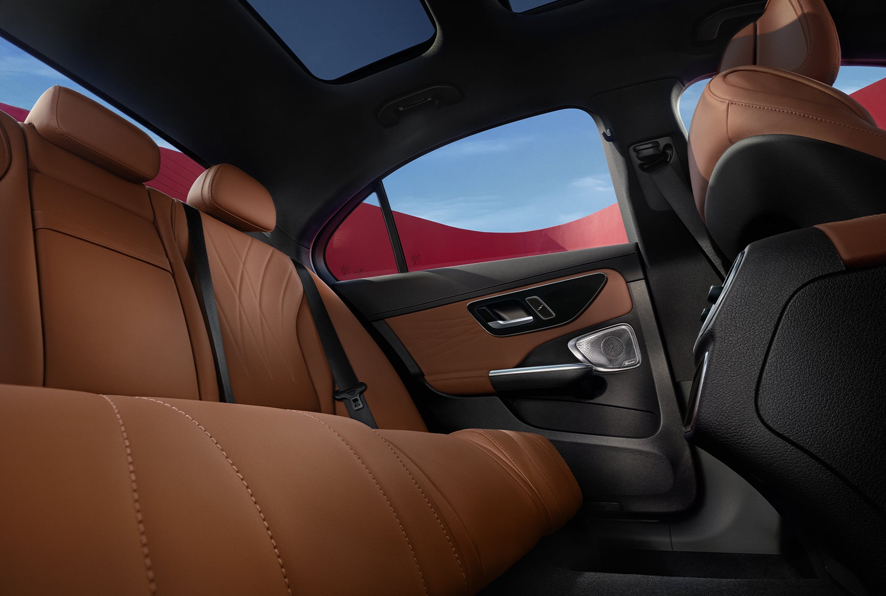 2027 Mercedes-Benz C-Class Sedan rear interior with brown leather seats, panoramic roof, and premium door trim.