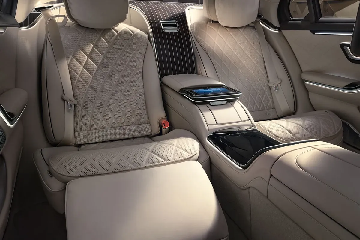 Alt: Rear executive seating in the Mercedes-Benz S-Class, with diamond-stitched leather and a luxury center console.