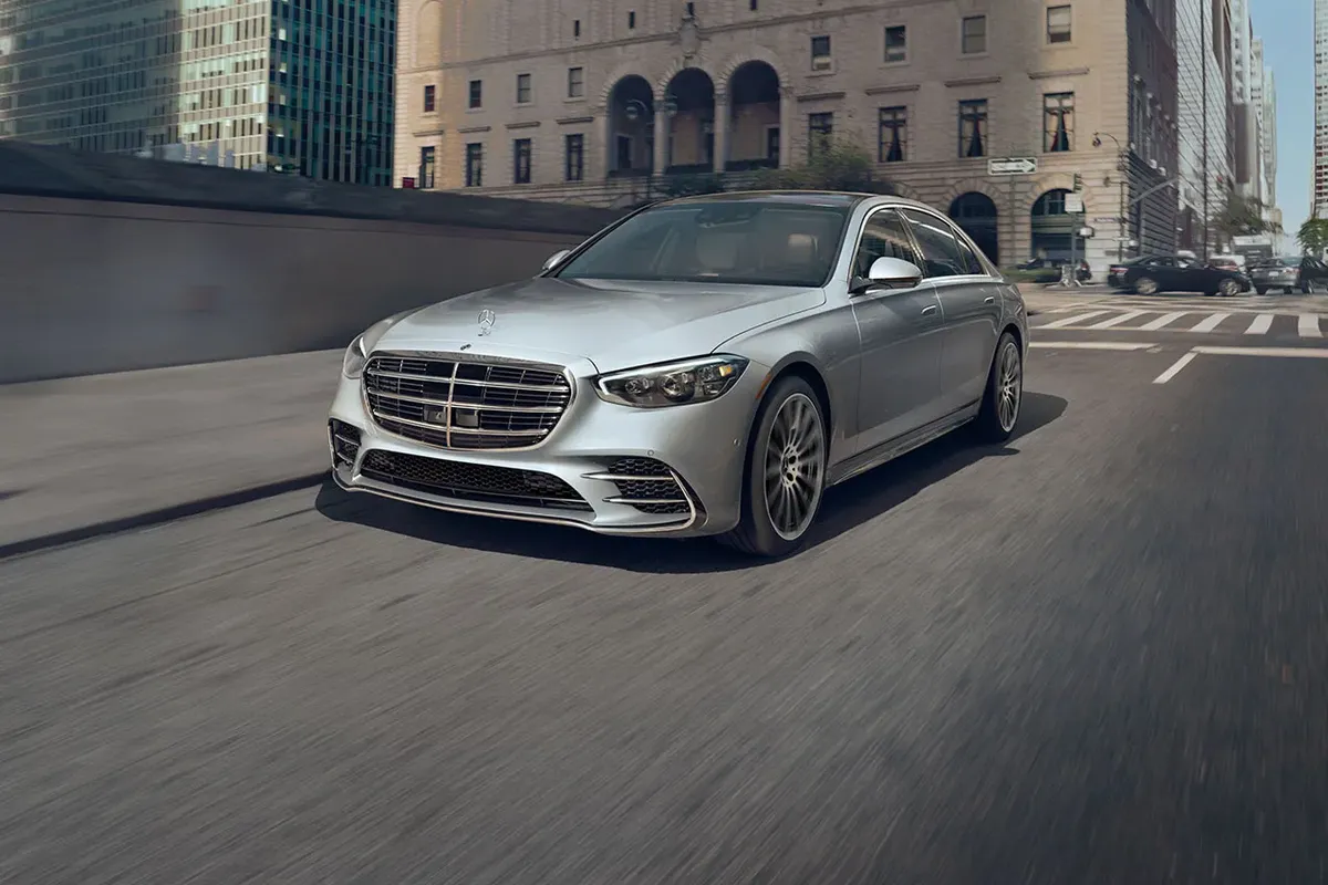 Mercedes-Benz S-Class driving confidently through the city, showcasing its sleek design and commanding presence.