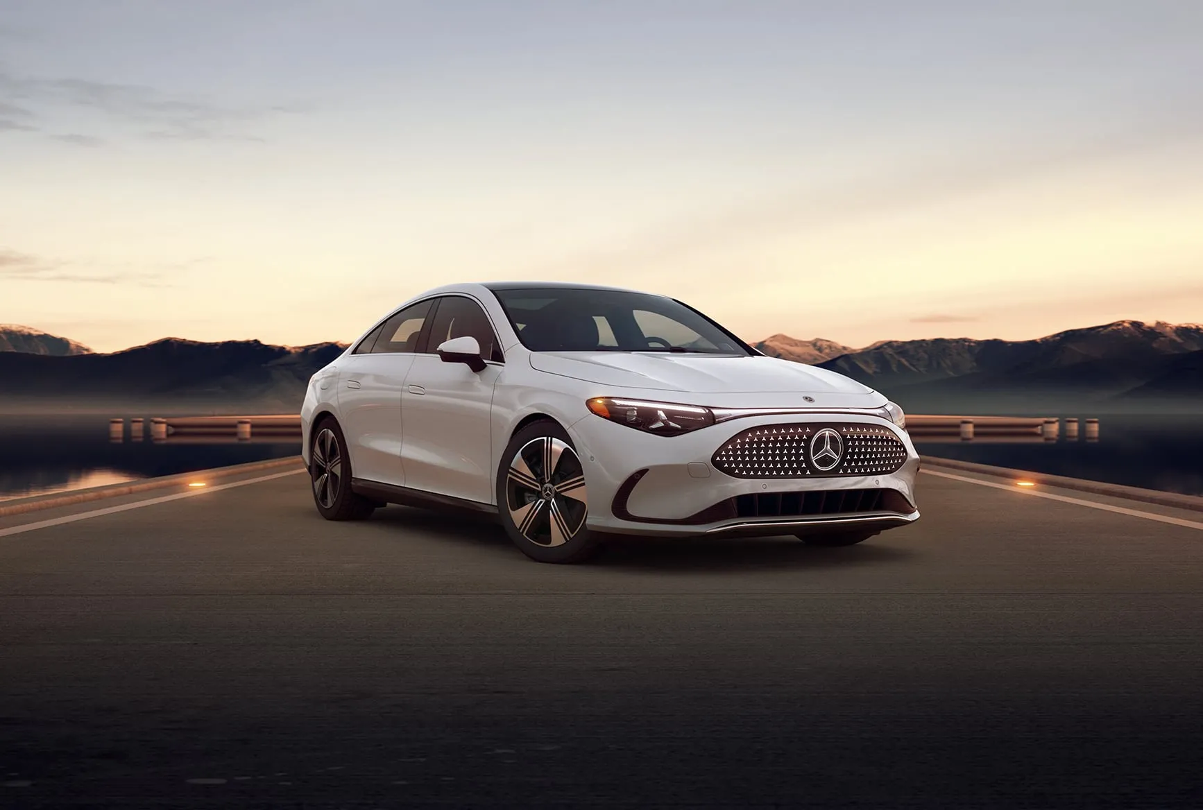White Mercedes-Benz CLA 350 electric coupe parked along scenic mountain highway at sunset – built for speed and efficiency.