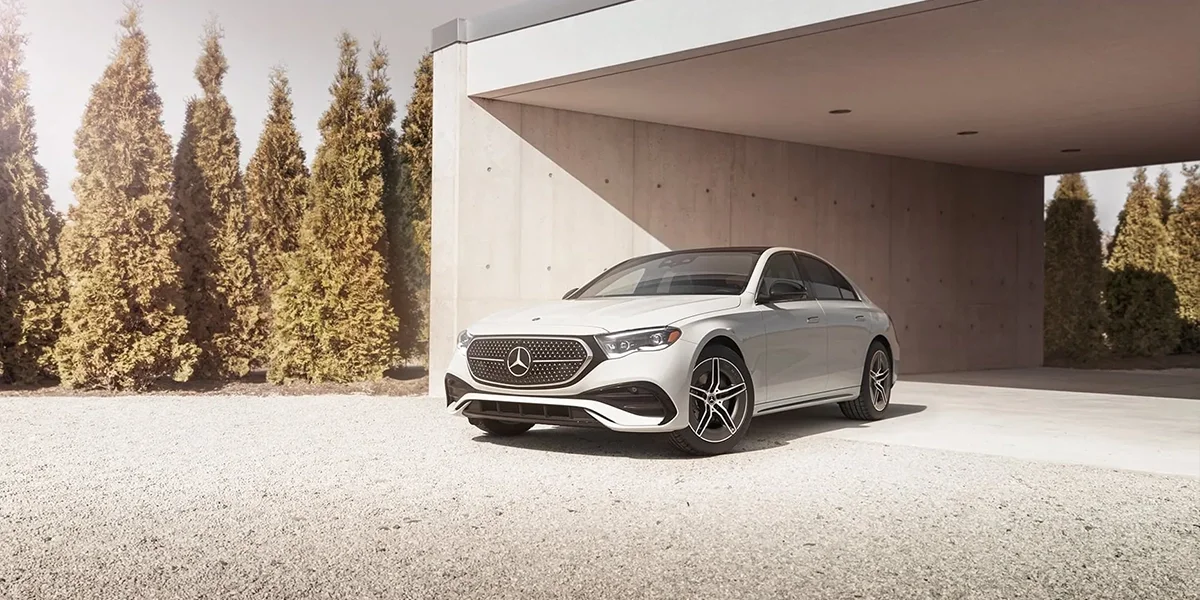 Mercedes-Benz E-Class white sedan in modern architectural setting with clean luxury design