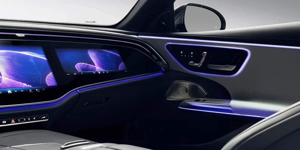 Mercedes-Benz E-Class rear interior with purple ambient lighting and luxury door panel design
